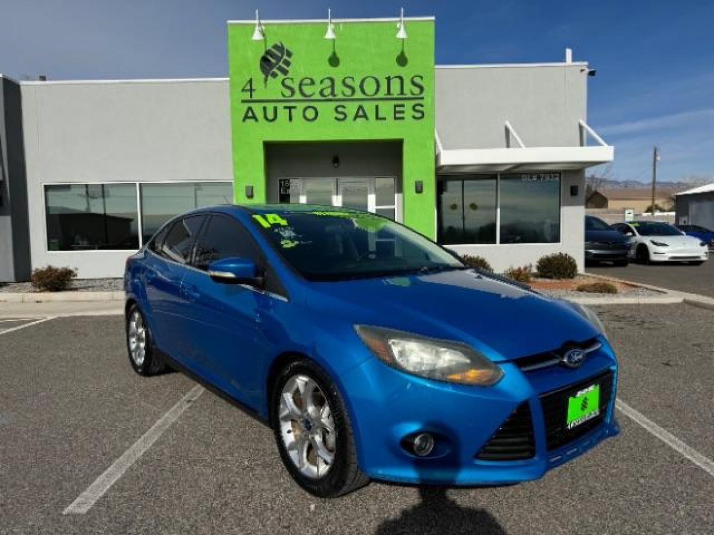 2014 Performance Blue Metallic /Charcoal Black Ford Focus Titanium Sedan (1FADP3J2XEL) with an 2.0L L4 DOHC 16V engine, 6-Speed Automatic transmission, located at 940 North Main Street, Cedar City, UT, 84720, (435) 628-0023, 37.692936, -113.061897 - Photo#0